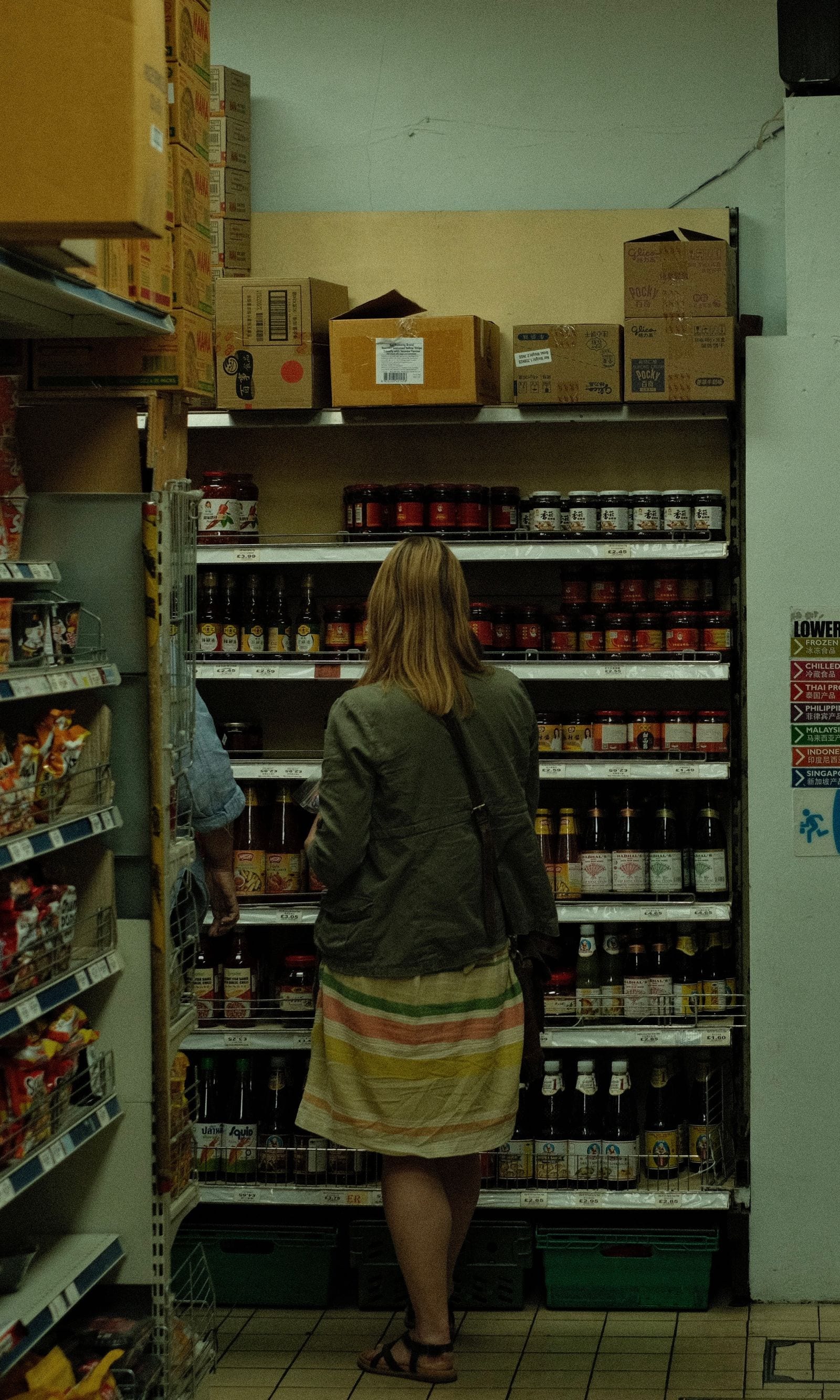 A shopper studies products on a grocery store shelf
